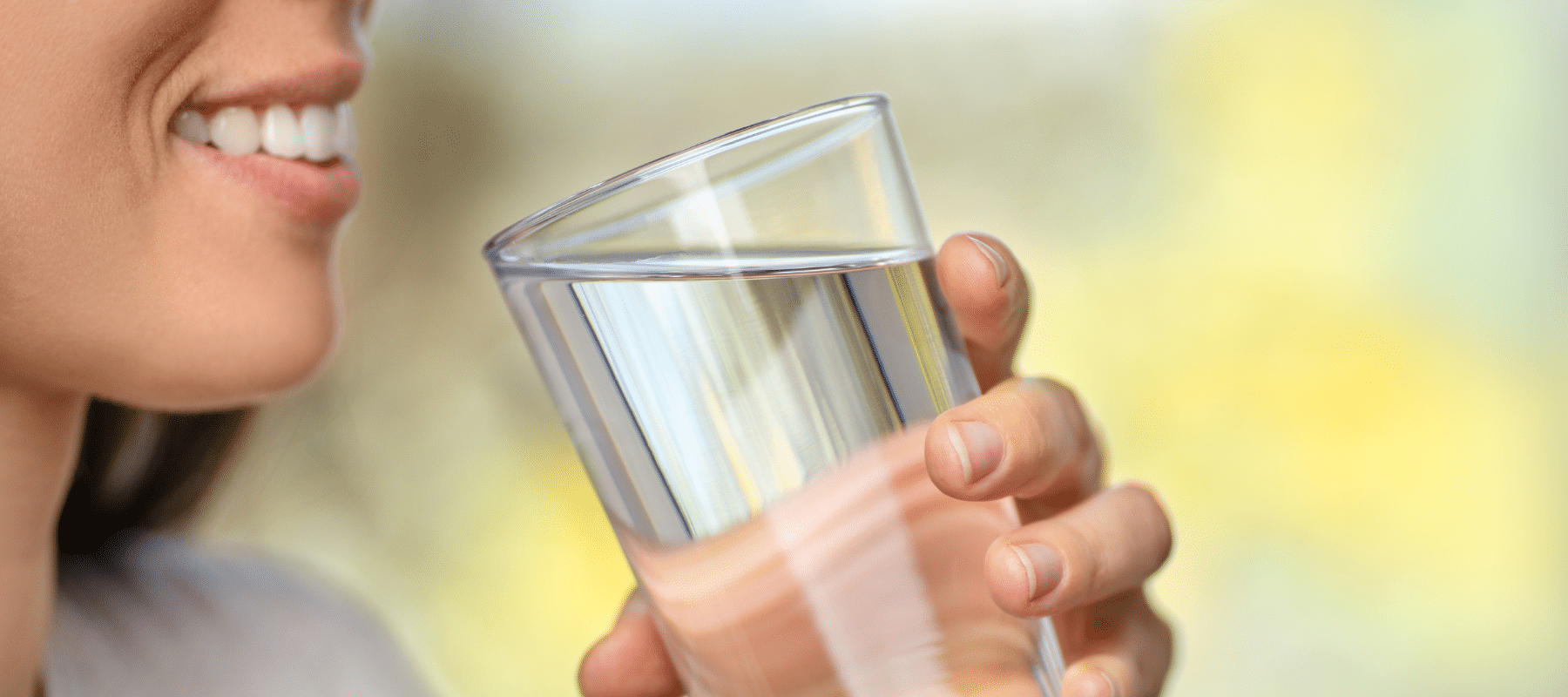 closeup of a young woman drinking a clear glass of water