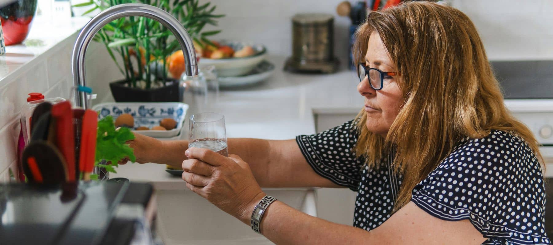 woman filling up glass with water
